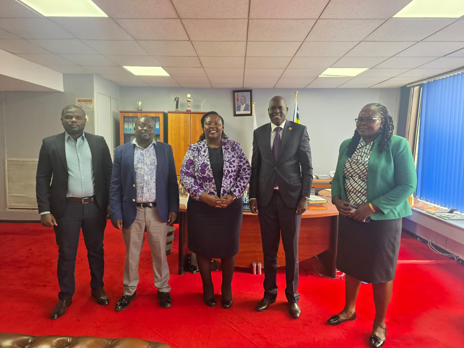 Dr. Laxmana Kiptoo poses for a photo with TI-Kenya Executive Director Sheila Masinde (on his right) at his office in Nairobi.