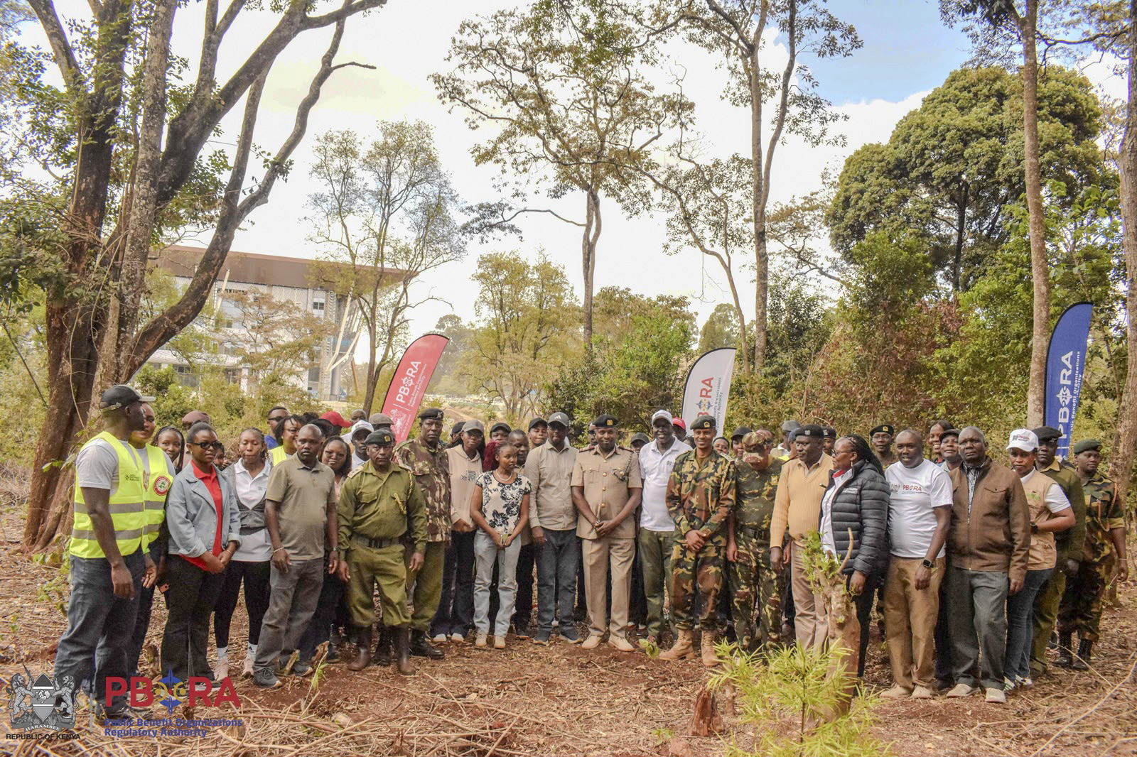 PBORA Staff pause for a group photo with KFS officers at the Ngong Road Forest. The Authority pledged to adopt an acre of forest land to grow trees.